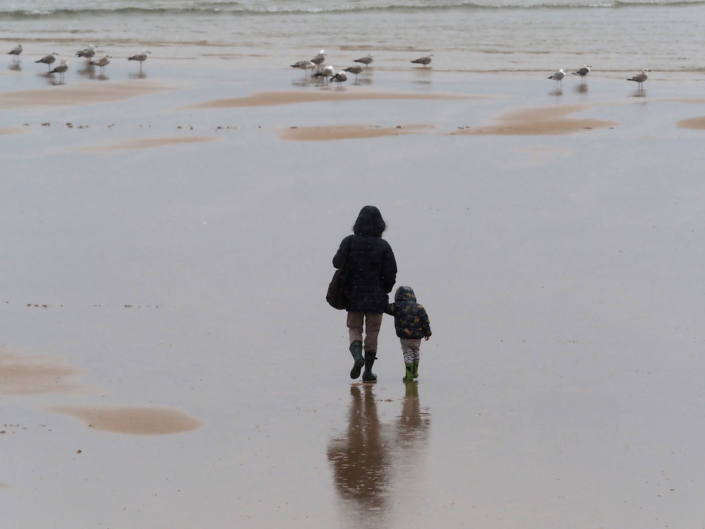 Primeros paseos bajo el orbayu en Gijón de los más pequeños