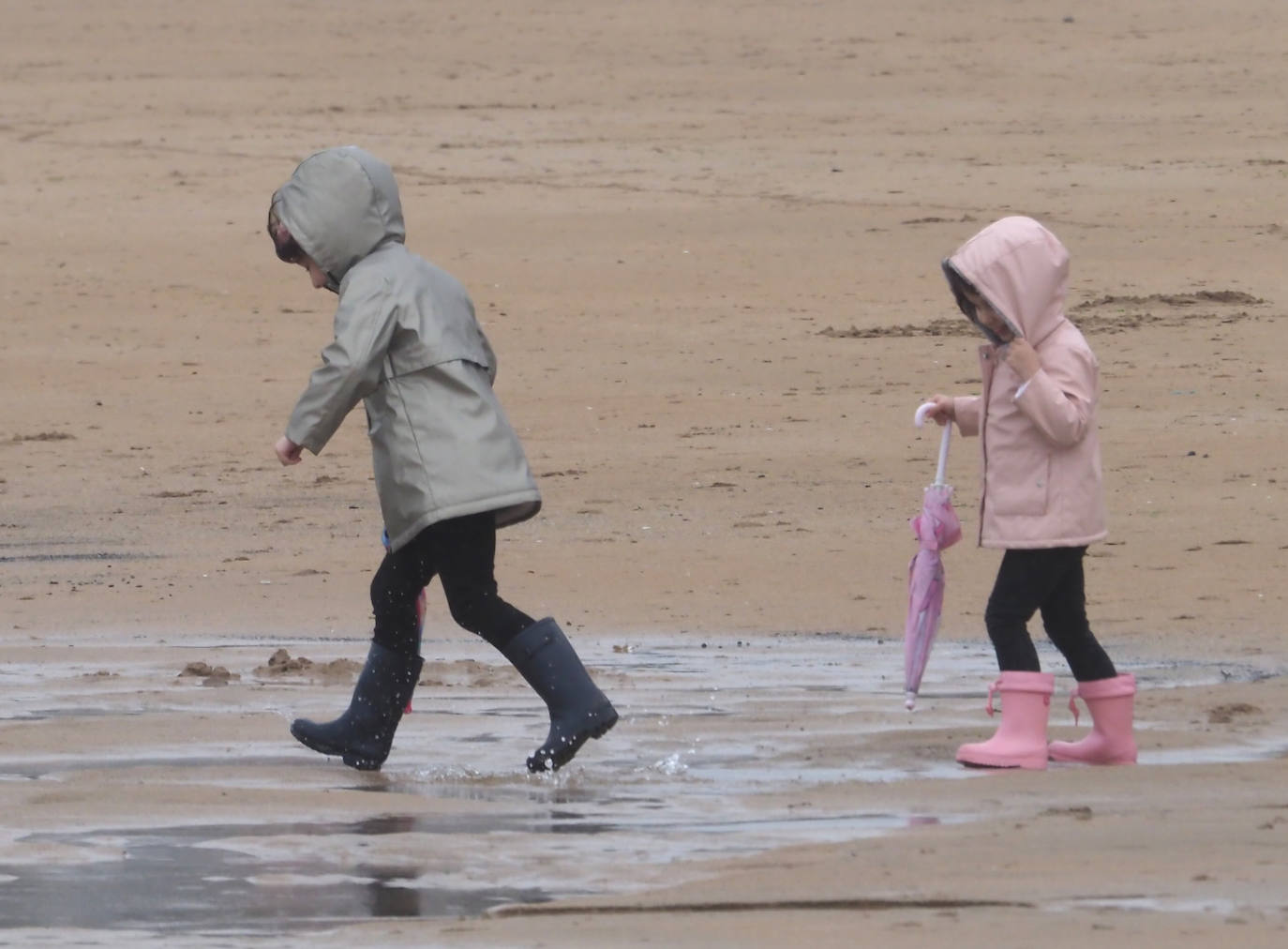 Primeros paseos bajo el orbayu en Gijón de los más pequeños