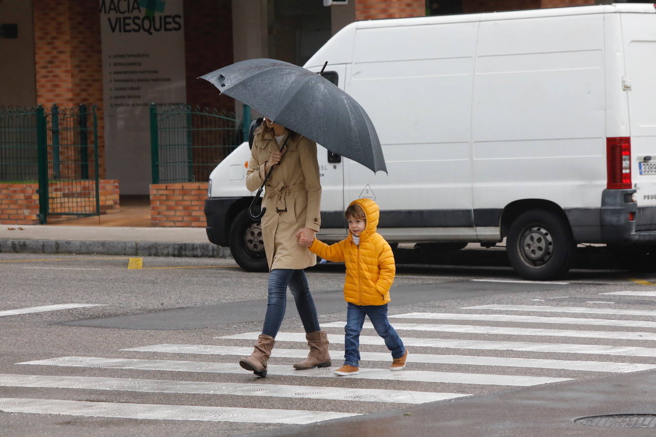 Primeros paseos bajo el orbayu en Gijón de los más pequeños