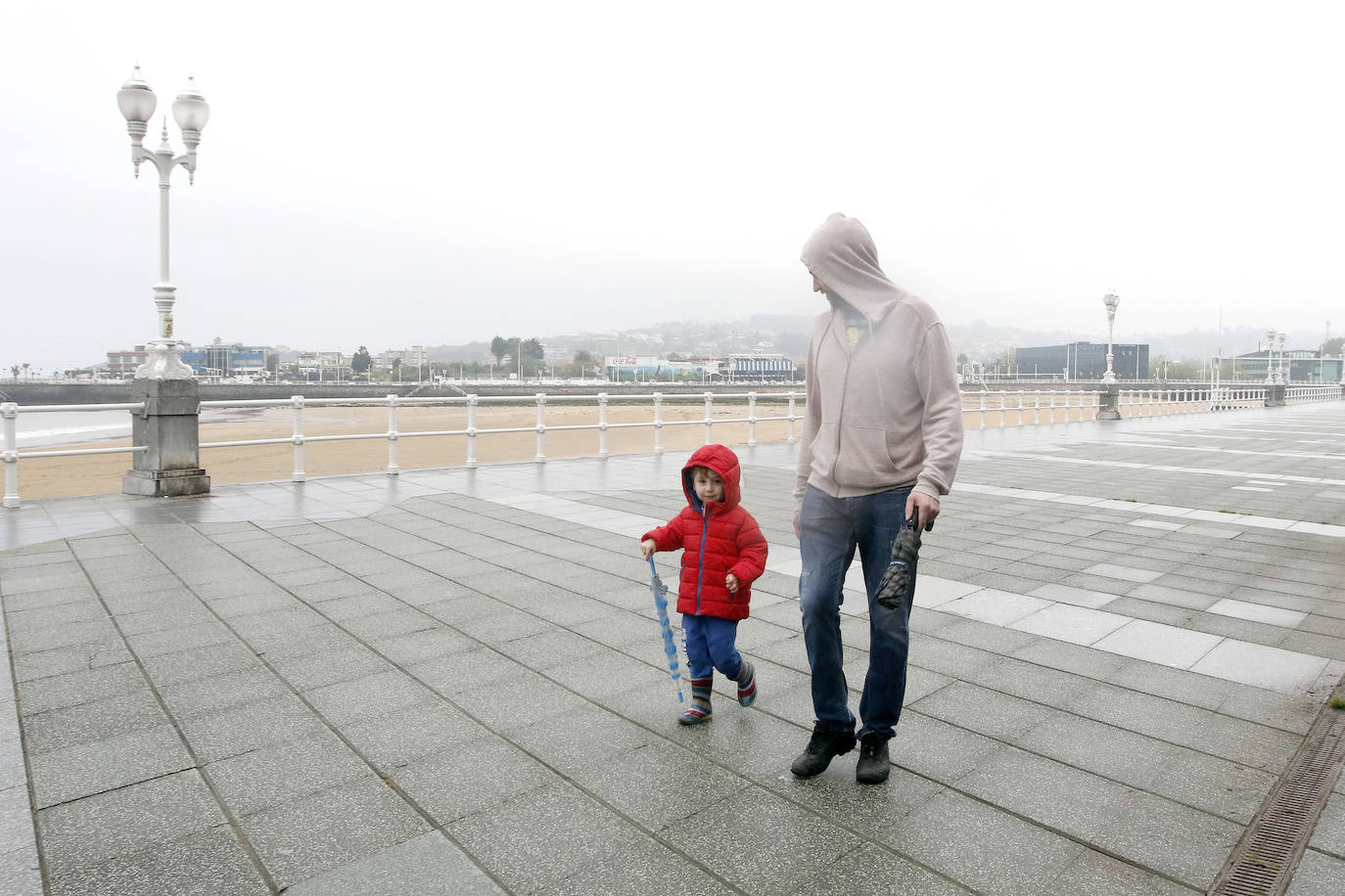 Primeros paseos bajo el orbayu en Gijón de los más pequeños