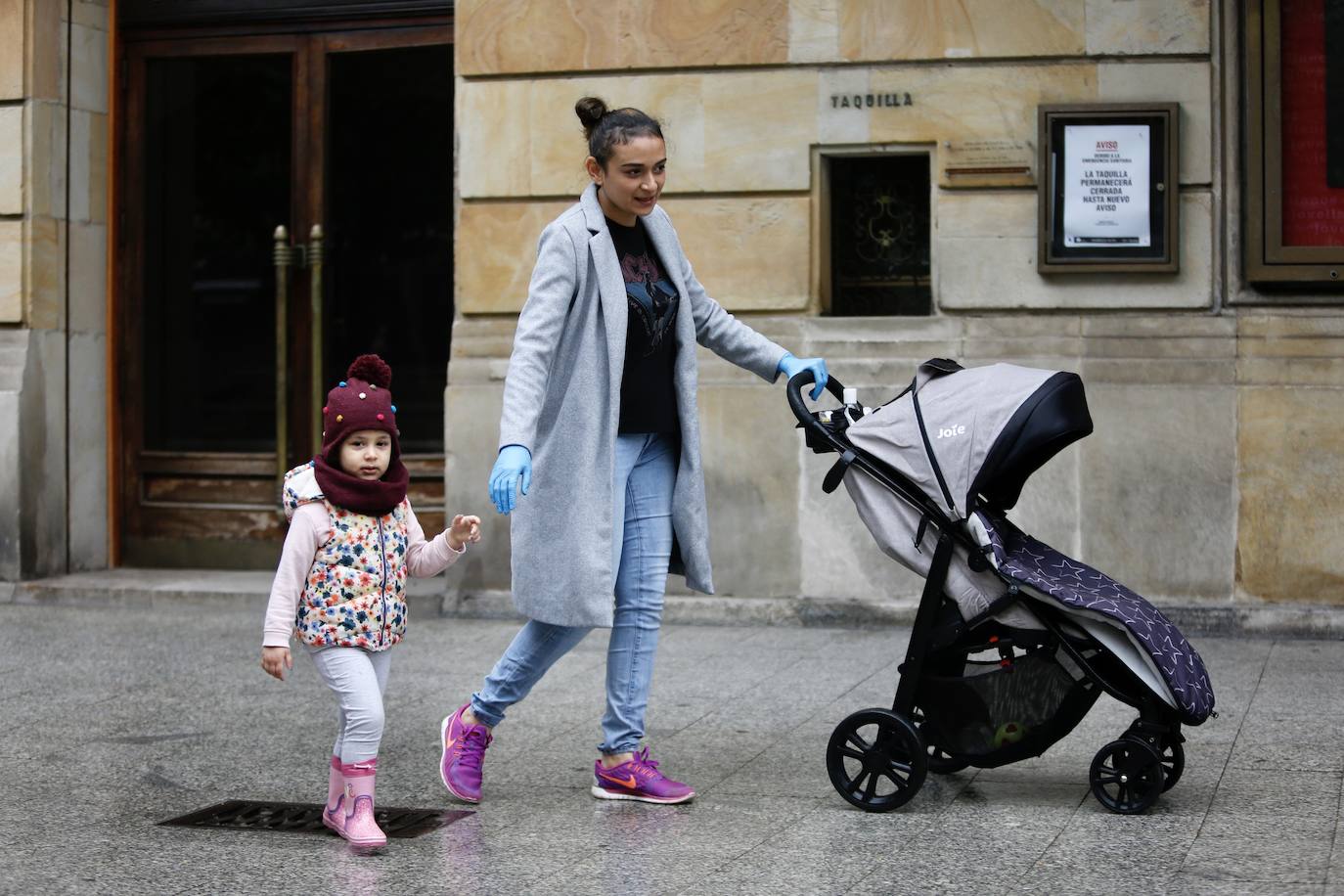 Primeros paseos bajo el orbayu en Gijón de los más pequeños