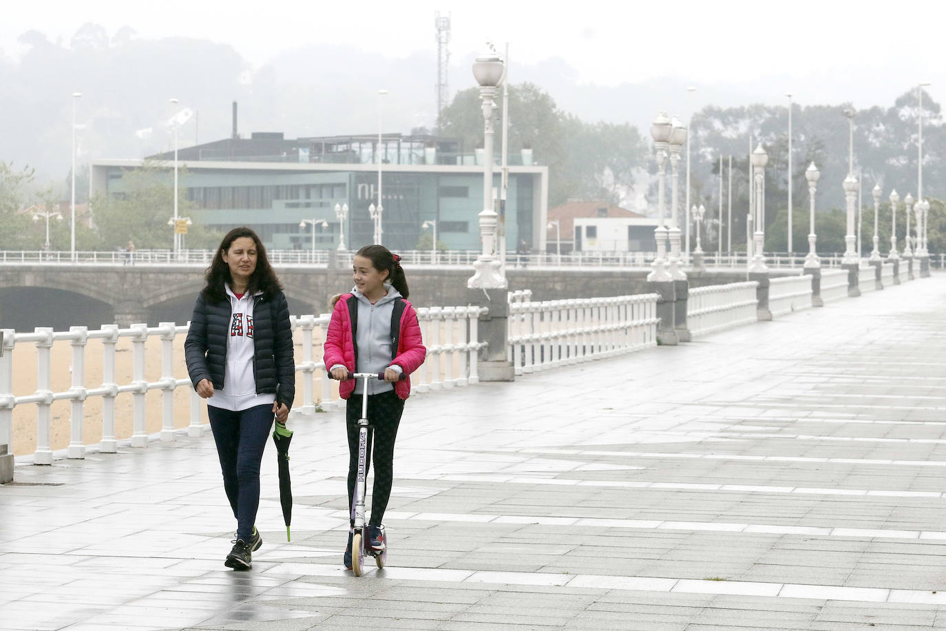 Primeros paseos bajo el orbayu en Gijón de los más pequeños