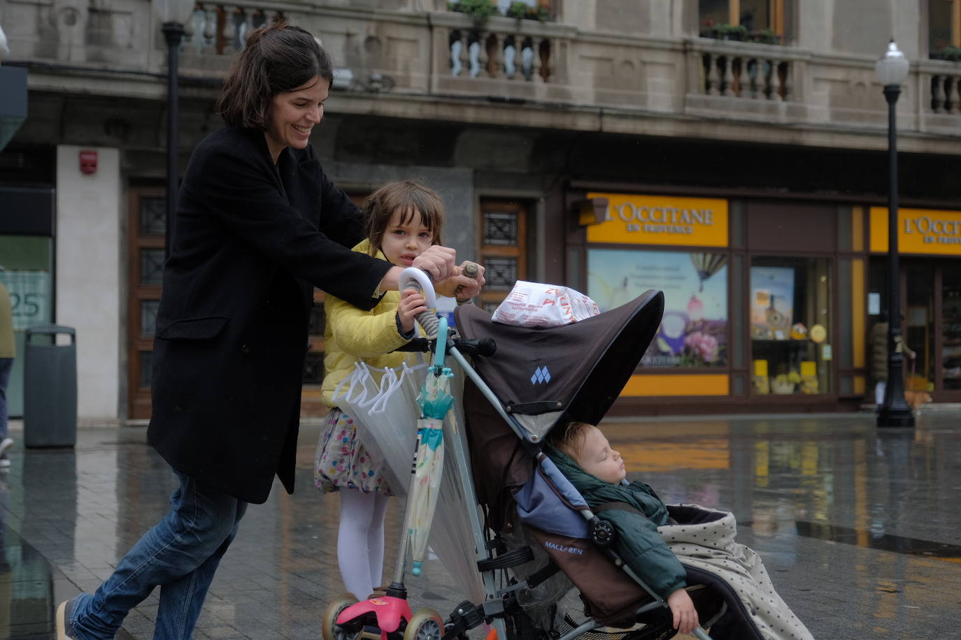 Primeros paseos bajo el orbayu en Gijón de los más pequeños