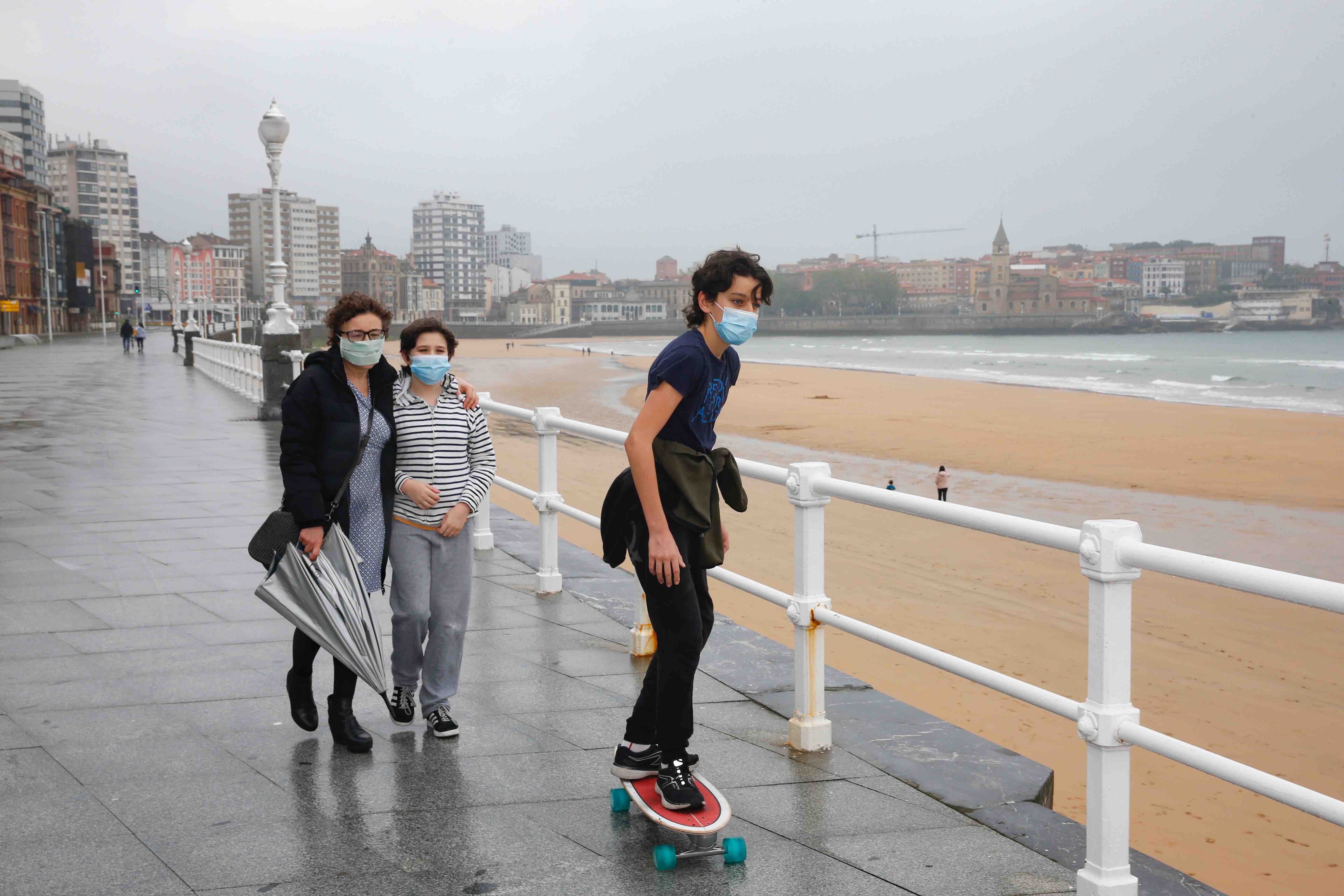 Primeros paseos bajo el orbayu en Gijón de los más pequeños