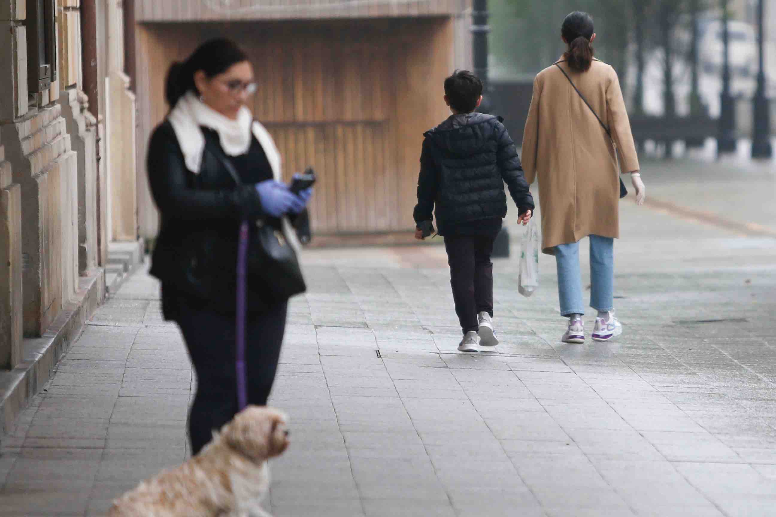 Primeros paseos bajo el orbayu en Gijón de los más pequeños