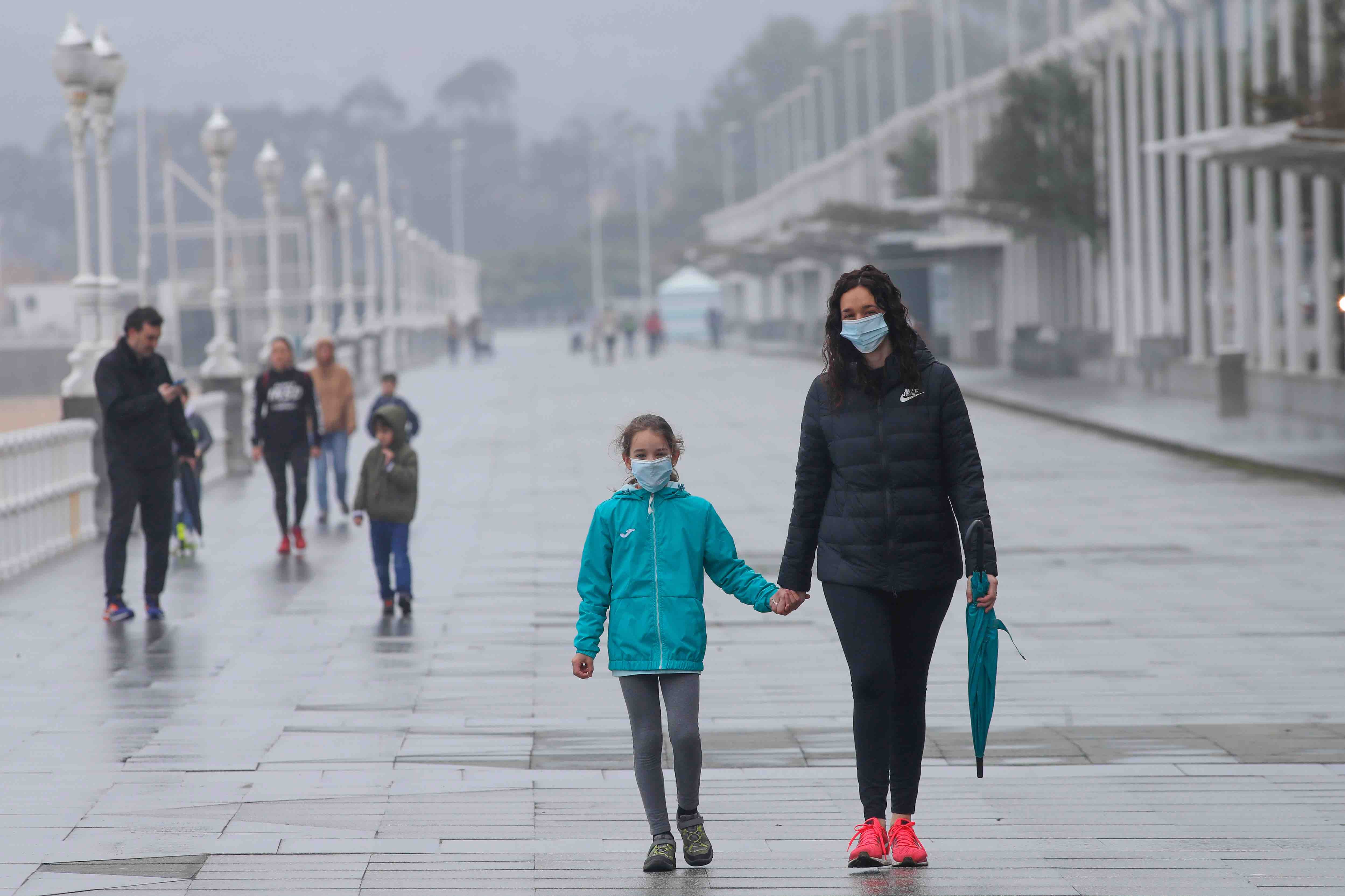 Primeros paseos bajo el orbayu en Gijón de los más pequeños