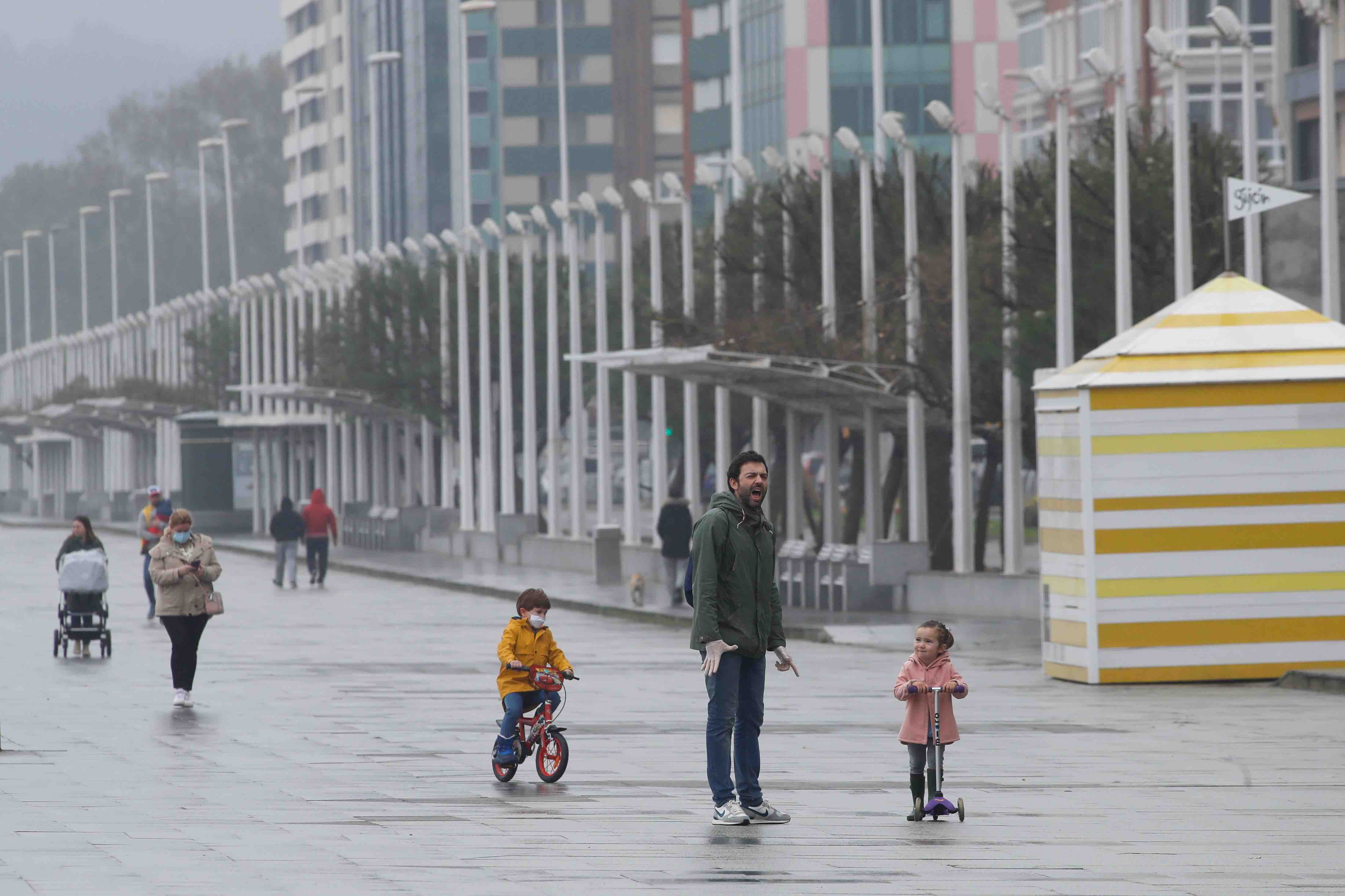 Primeros paseos bajo el orbayu en Gijón de los más pequeños