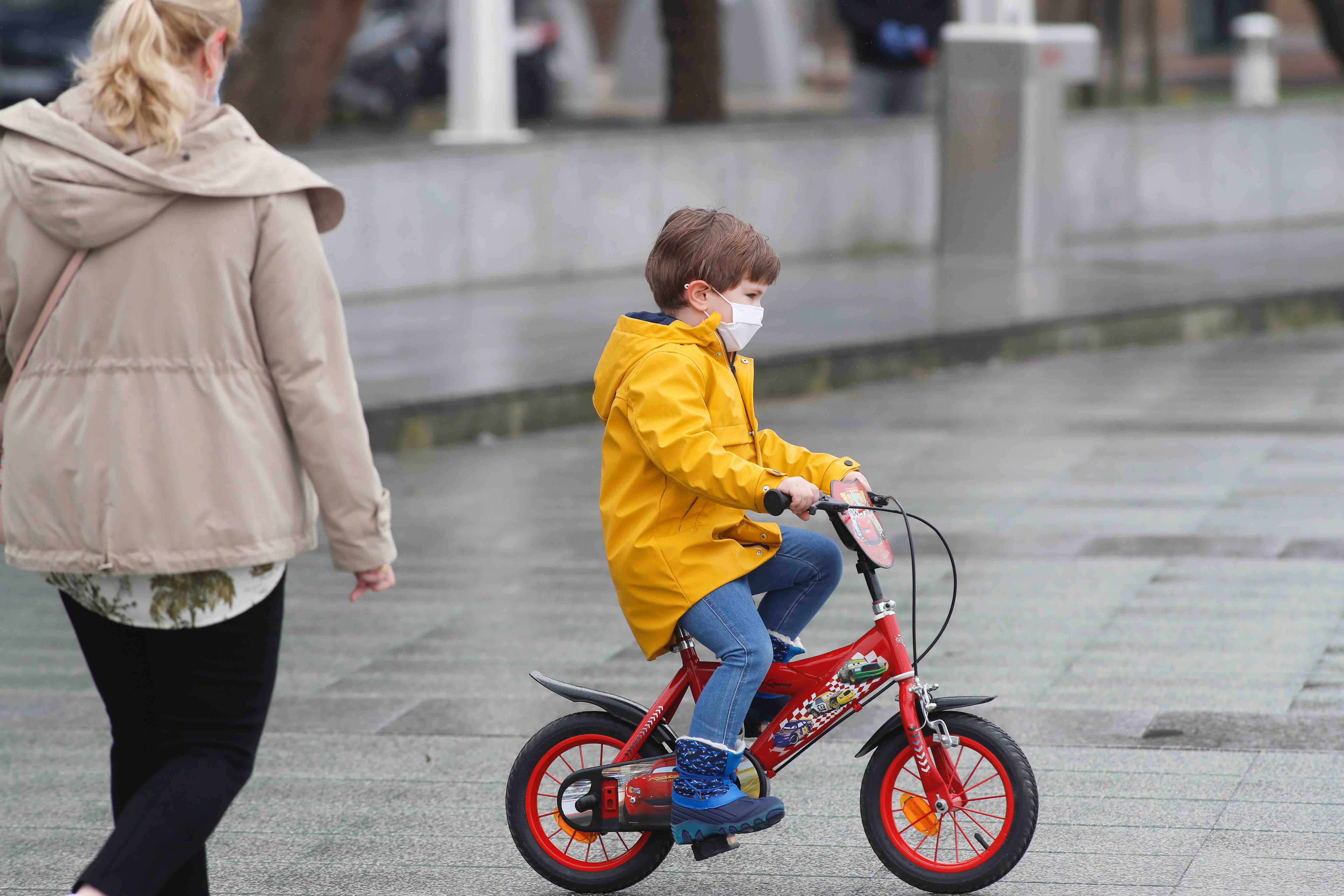 Primeros paseos bajo el orbayu en Gijón de los más pequeños