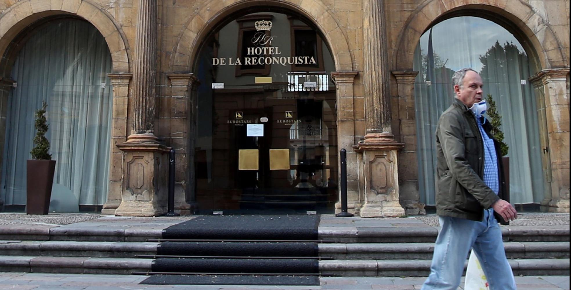 Un hombre con mascarilla delante del Hotel de la Reconquista. 