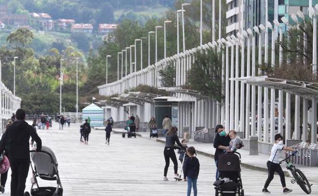 Padres con sus hijos ayer en El Muro. En el vídeo, explicación sobre el estado de alarma. 