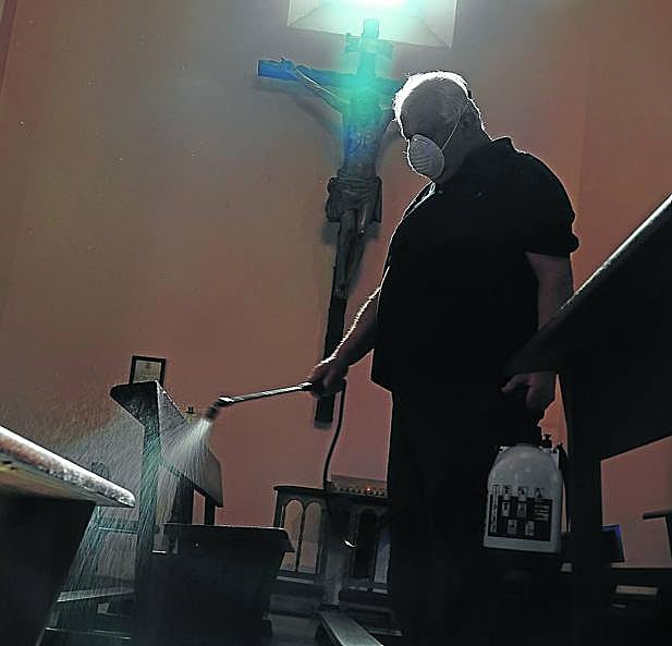 Amaro Balbín, párroco de Arriondas, desinfecta la iglesia de San Martín, en la capital parraguesa