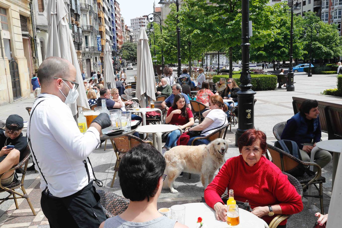 Tras ocho semanas con las verjas bajadas y las sillas y mesas apiladas, los establecimientos hosteleros de Gijón han vuelto a colocar sus terrazas. Eso sí, bajo estrictas medidas de higiene y aforo para prevenir el contagio de coronavirus. 