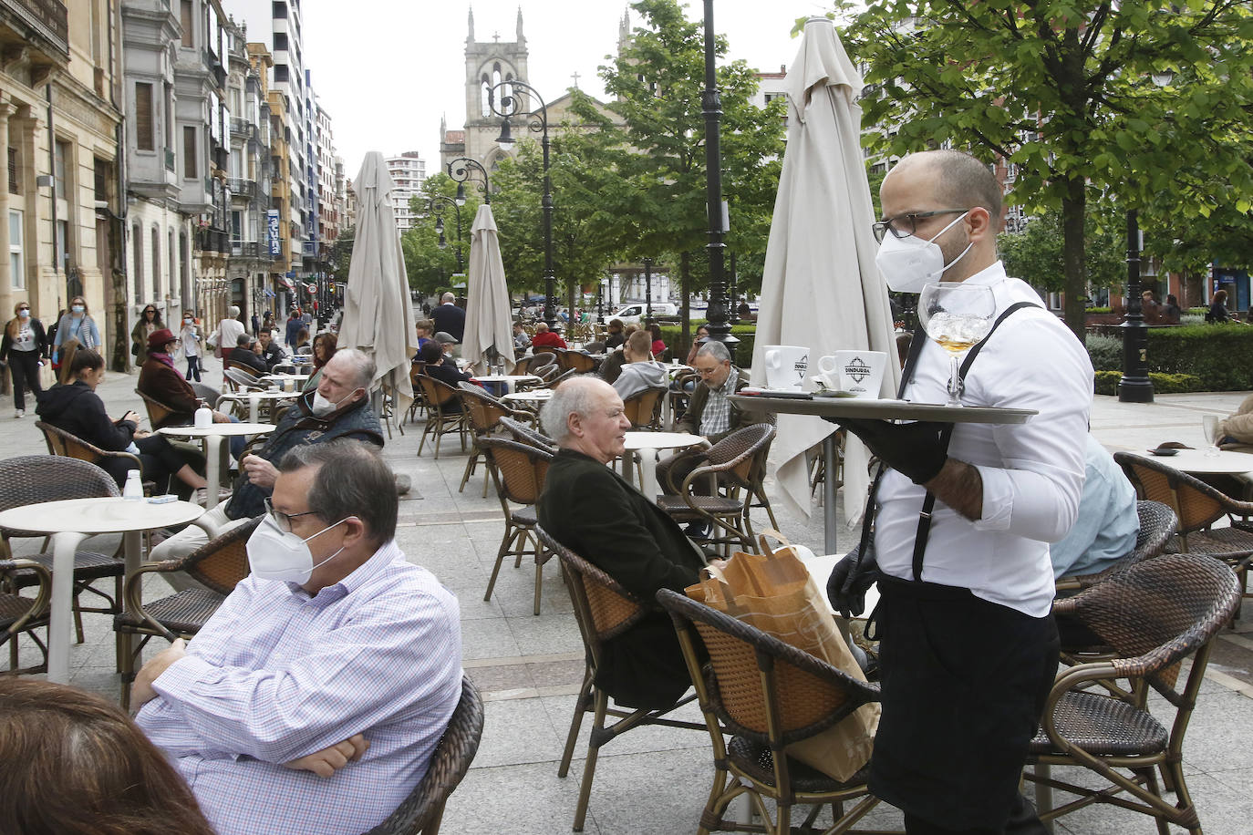 Por primera vez desde que se declaró el estado de alarma por la pandemia de coronavirus los asturianos han podido acudir a las terrazas de bares y cafeterías. Este lunes ha comenzado la fase 1 de la desescalada en el Principado y una de las medidas de alivio del confinamiento es la apertura de terrazas, aunque los establecimientos hosteleros deben acatar estrictas medidas de precaución, como la limpieza exhaustiva de las sillas y mesas o la limitación de aforo. 