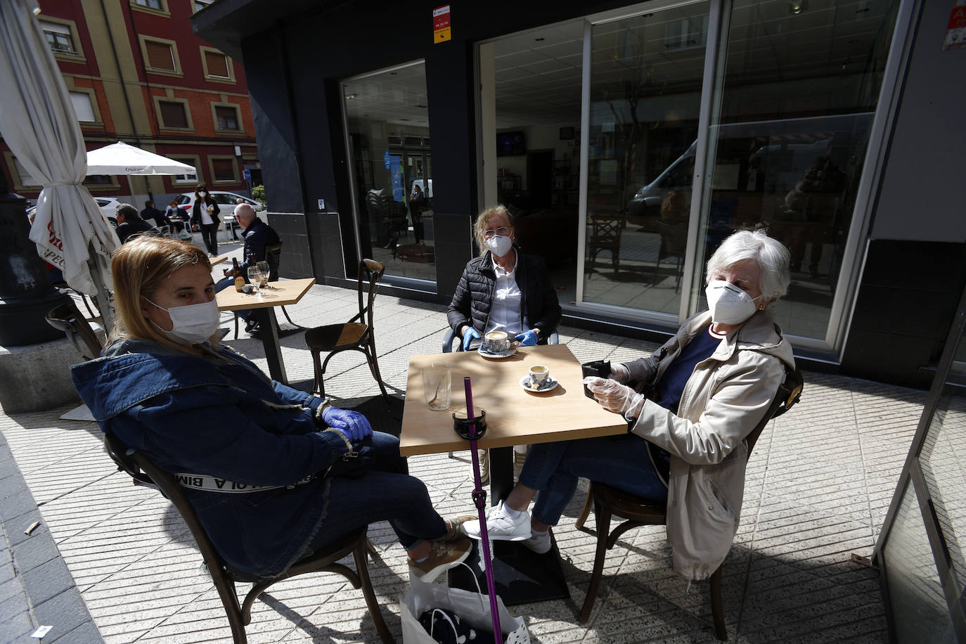 Por primera vez desde que se declaró el estado de alarma por la pandemia de coronavirus los asturianos han podido acudir a las terrazas de bares y cafeterías. Este lunes ha comenzado la fase 1 de la desescalada en el Principado y una de las medidas de alivio del confinamiento es la apertura de terrazas, aunque los establecimientos hosteleros deben acatar estrictas medidas de precaución, como la limpieza exhaustiva de las sillas y mesas o la limitación de aforo. 