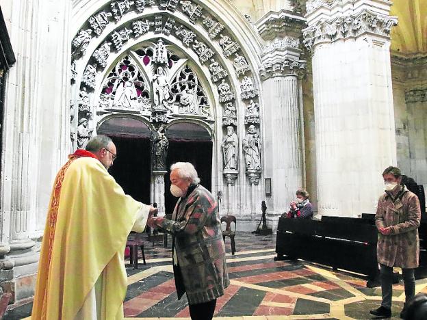 Sanz Montes dando la comunión en la mano de una de las fieles que acudió ayer a misa. 