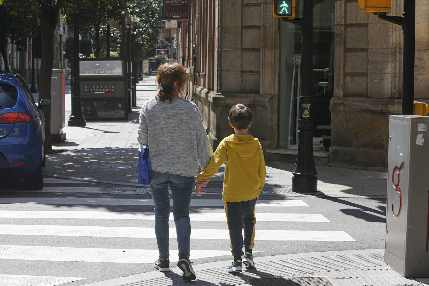 20 de abril. Gijón | Una mujer y un niño por la calle durante el confinamiento. 