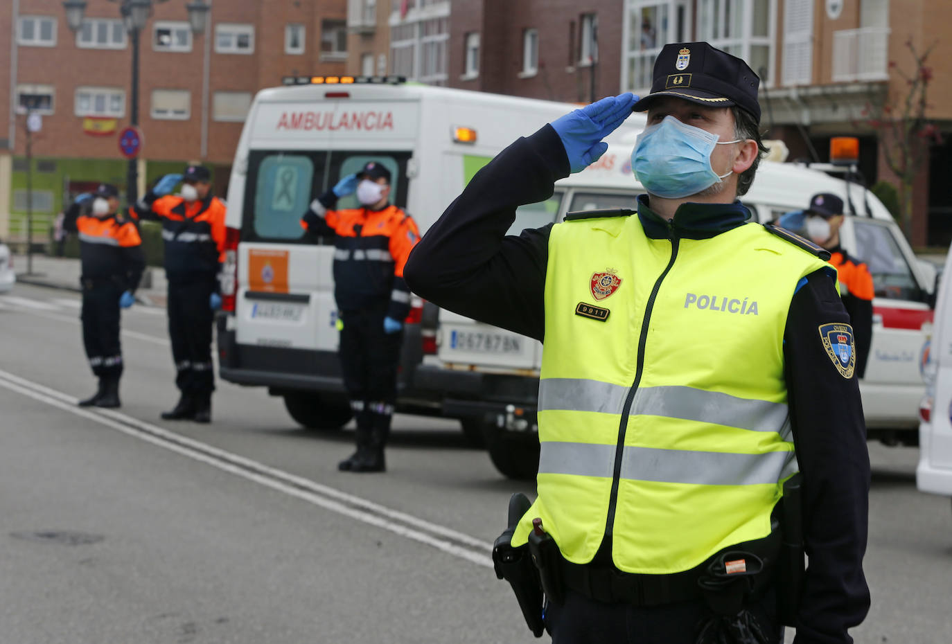25 de abril. Oviedo | Policía Local, Bomberos y Protección Civil guardan un minuto de silencio en memoria de los fallecidos por el coronavirus en a plaza de El Conceyín arropados por los vecinos de La Corredoria. 