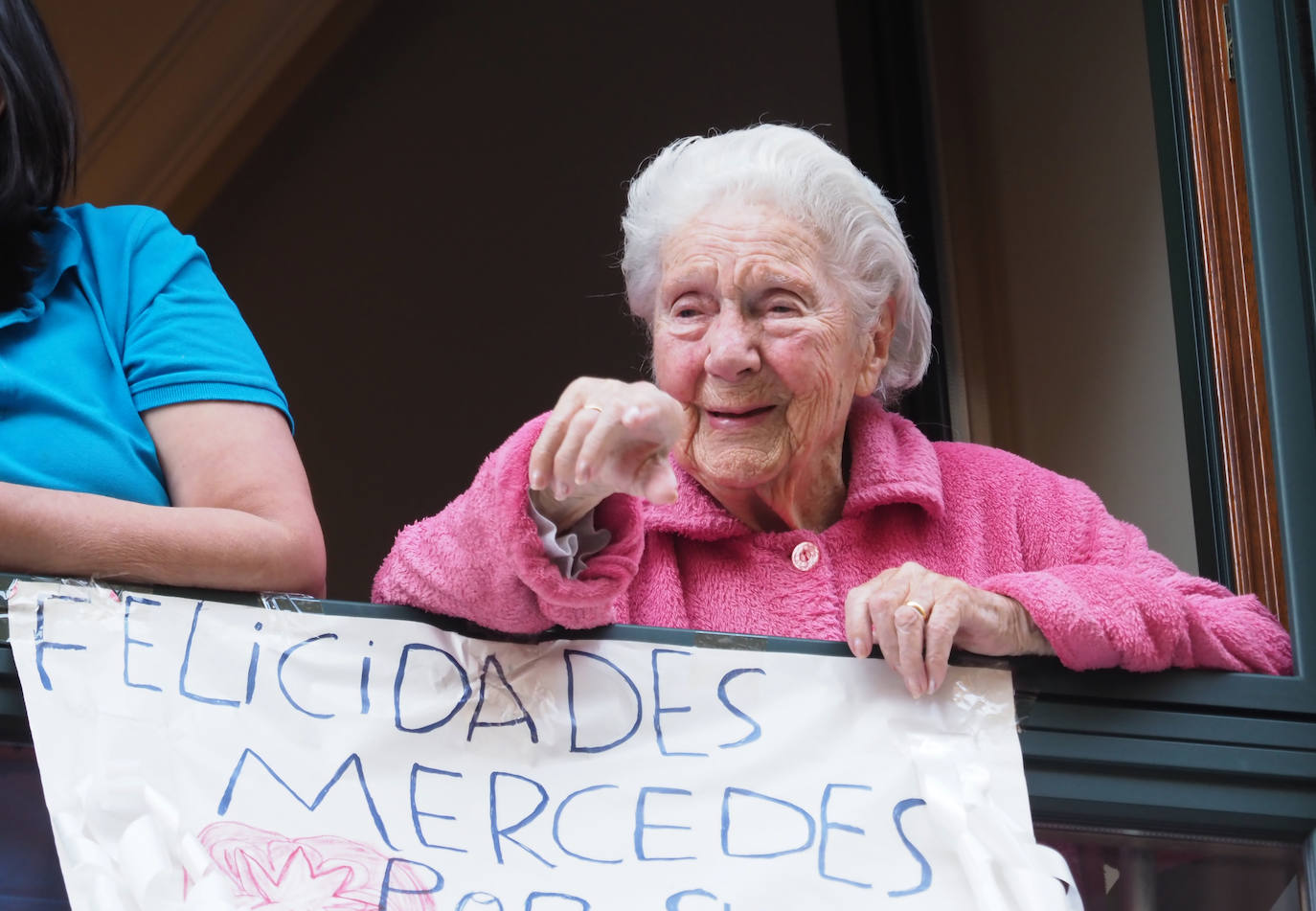 04 de mayo. Gijón | Mercedes Álvarez, asomada a su ventana, en Santa Doradía, celebra su 103 cumpleaños con los vecinos para los aplausos de las ocho. 