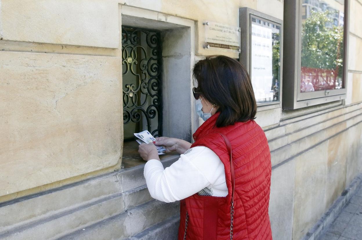 Una mujer solicita la devolución del importe en la taquilla. 