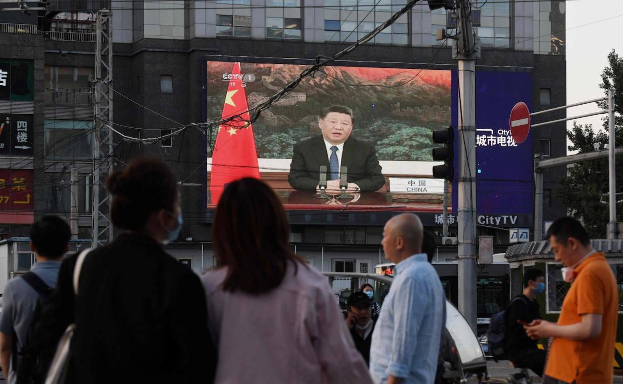 Los ciudadanos observan en una gran pantalla, instalada en una calle de Pekin, la intervención del presidente chino ante la Asamblea Popular Nacional. 