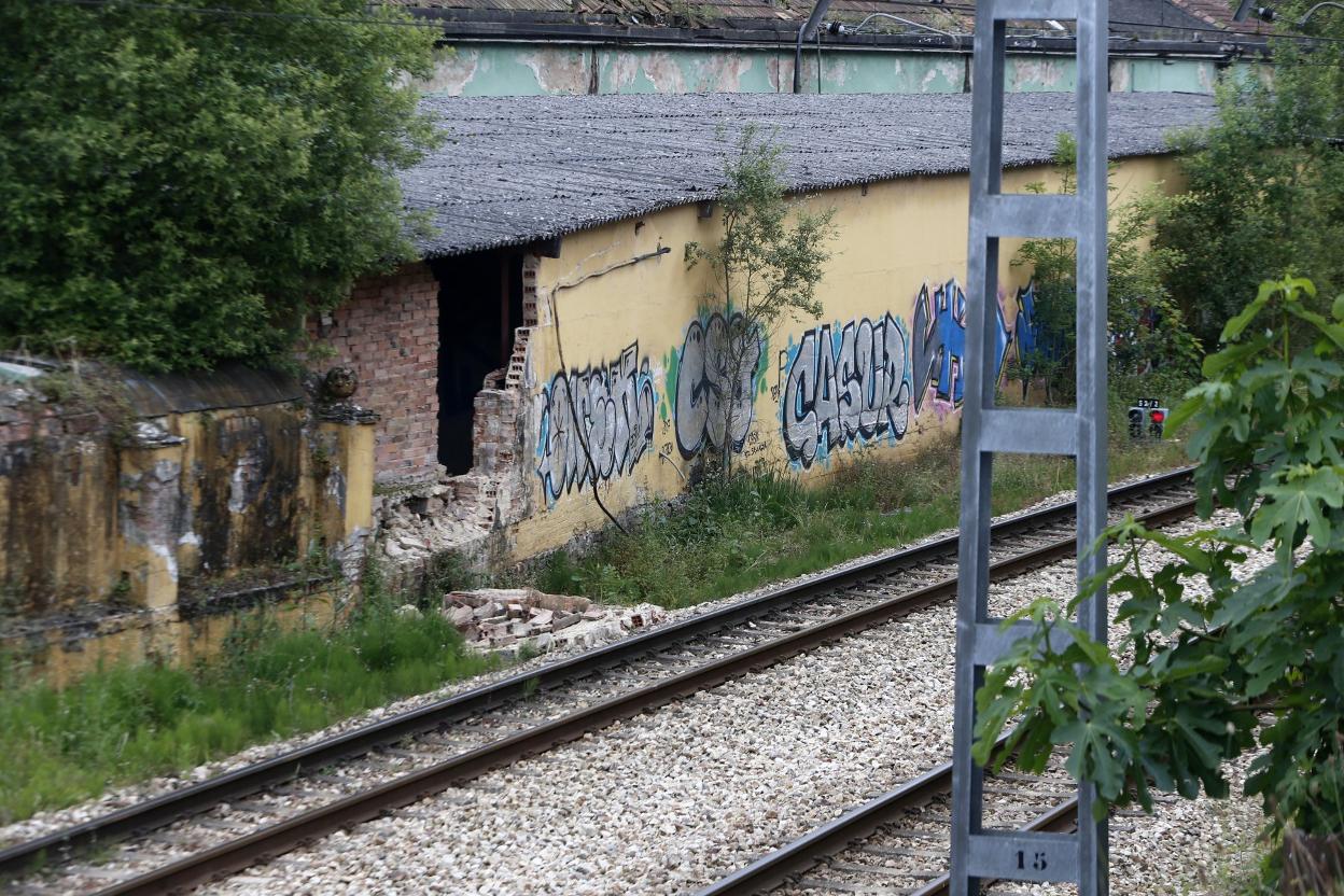 El muro de la factoría, caído al lado de las vías. 