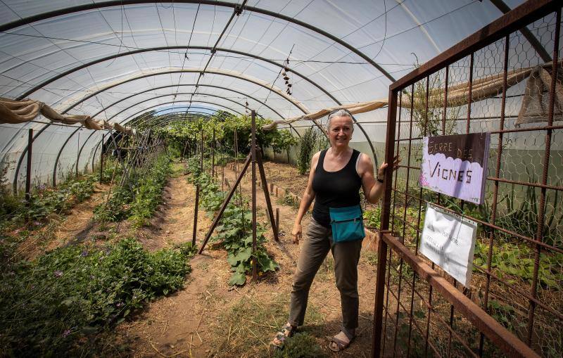 Una aldeana muestra uno de los huertos del asentamiento ecológico Los Portales de Castilblanco de los Arroyos (Sevilla)