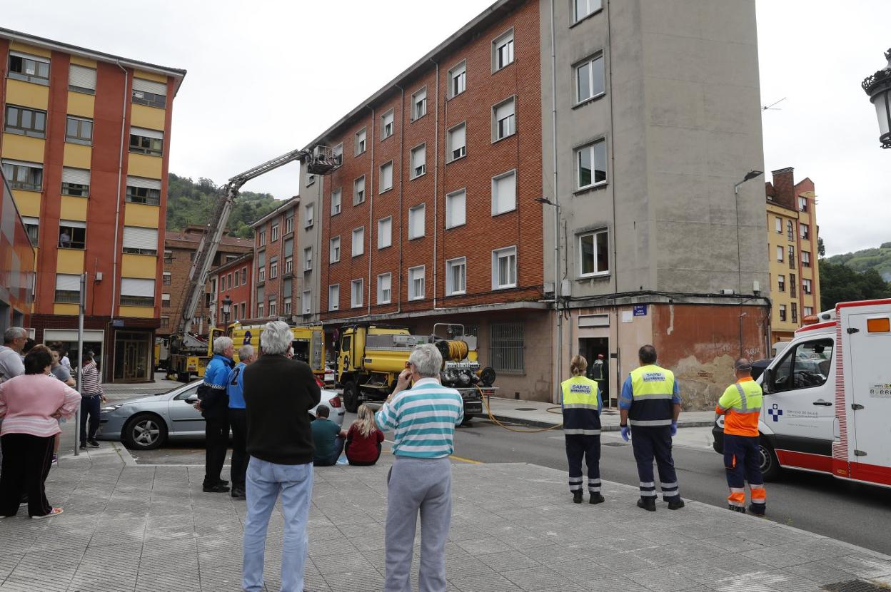 Los bomberos, durante las labores de extinción del incendio declarado en un piso de la calle Jacinto Benavente. 
