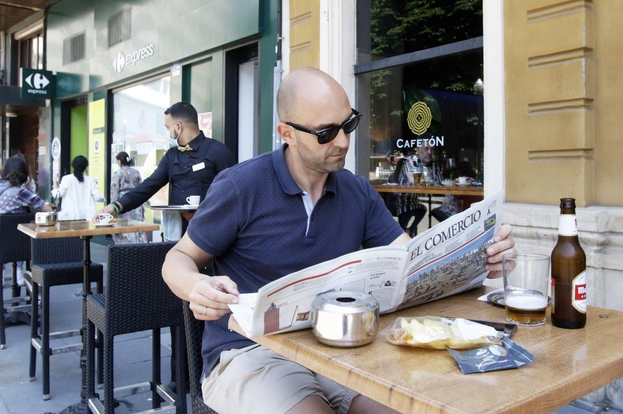 Un lector de EL COMERCIO, en una terraza de La Plazuela, en Gijón . 