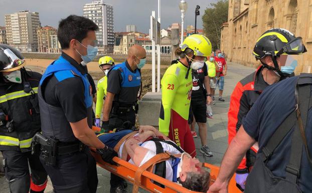 Imagen. Una mujer, herida tras caerse a las rocas desde la escalera 1 de la playa de San Lorenzo. 