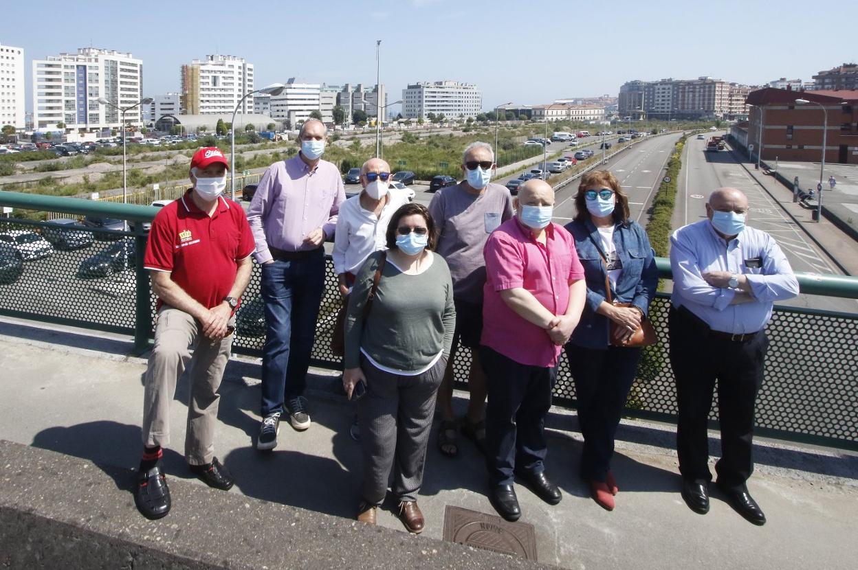 De izquierda a derecha Alfredo Lorenzo (El Natahoyo), Julio Gómez (Poniente), Florencio Martín (Laviada), Maite Martín (centro), Manuel Cañete (El Polígono y Federación Vecinal Urbana), Fermín Entrialgo (Tremañes), Teresa Prada (La Calzada) y Álvaro Tuero (El Natahoyo), en el viaducto de Carlos Marx. 