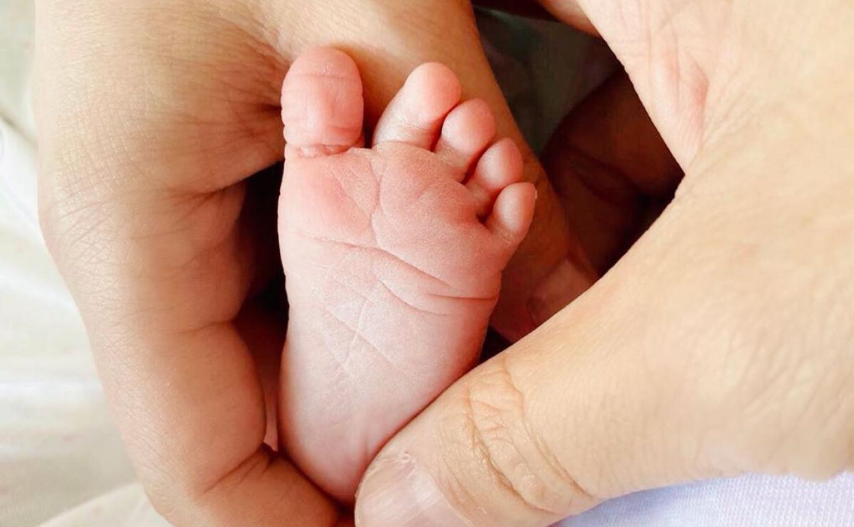 Imagen de las manos de Malú y Albert Rivera con el pie de su hija. 