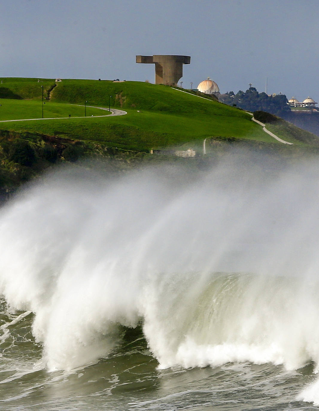 Las olas rompen bajo el cerro. 