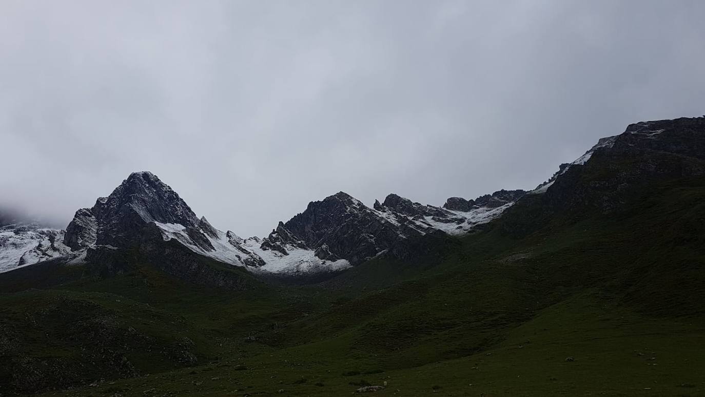 A falta de poco más de una semana para que llegue el verano, la cota de nieve en el Principado ha descendido hasta los 1.5000 metros, lo que ha provocado estampas más propias del invierno en las cimas asturianas, que han amanecido nevadas. 