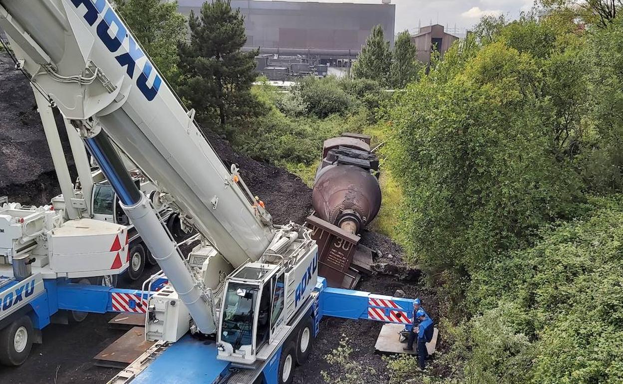 Dos grúas maniobran para intentar rescatar el torpedo descarrillado en Tabaza. 