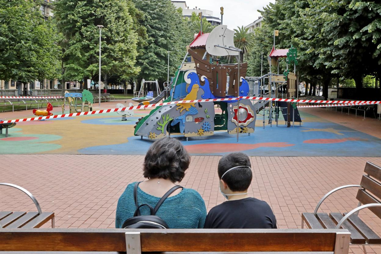 Una mujer y su hijo en Begoña, frente a la juegos cerrados ayer. 