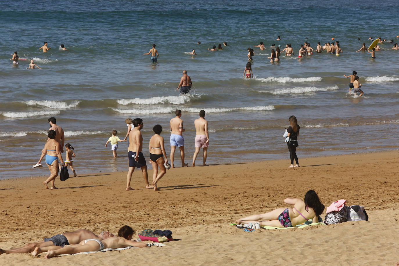 El sol y el buen tiempo han animado este jueves a disfrutar de las playas de Gijón. 