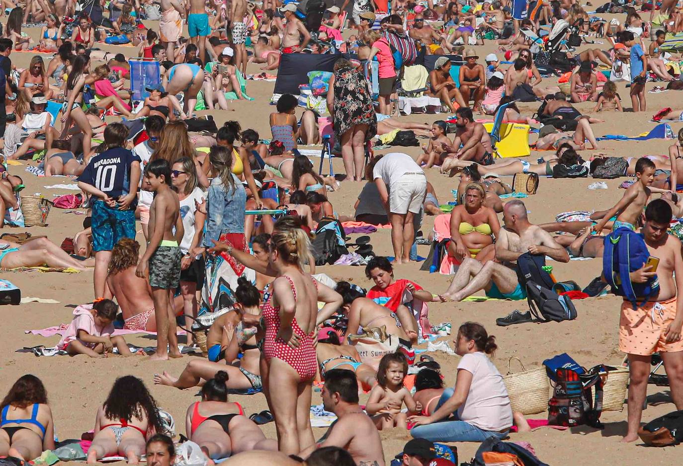El sol y el calor llevó a la gente a las playas de Gijón. Y lo hizo en masa. Hubo tanta afluencia que incluso tuvo que cerrarse el acceso al principal arenal gijonés, San Lorenzo, para recolocar a las personas. Los acomodadores hoy tuvieron trabajo a destajo para informar a la gente de las condiciones de uso de la playa.