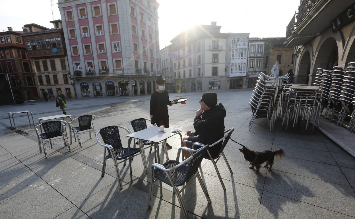 Un cliente, en la terraza de un bar de la Plaza de España de Avilés. 