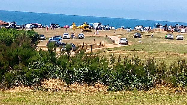 El helicóptero del SEPA deposita a una de las mujeres rescatadas en las inmediaciones de la playa. 