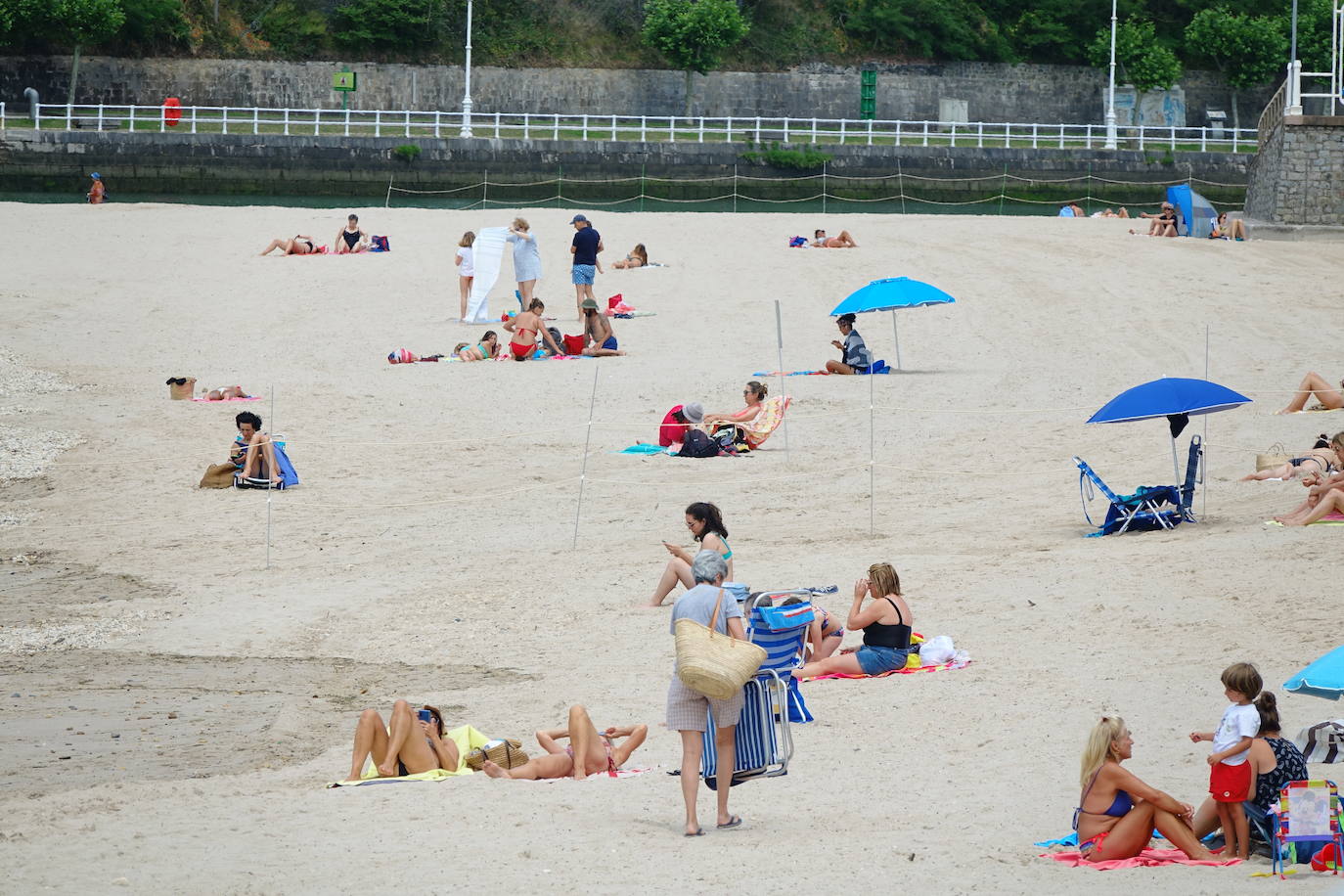 Asturianos y visitantes despiden junio con unas elevadas temperaturas que les ha llevado hasta playas y zonas de paseo con sombra.