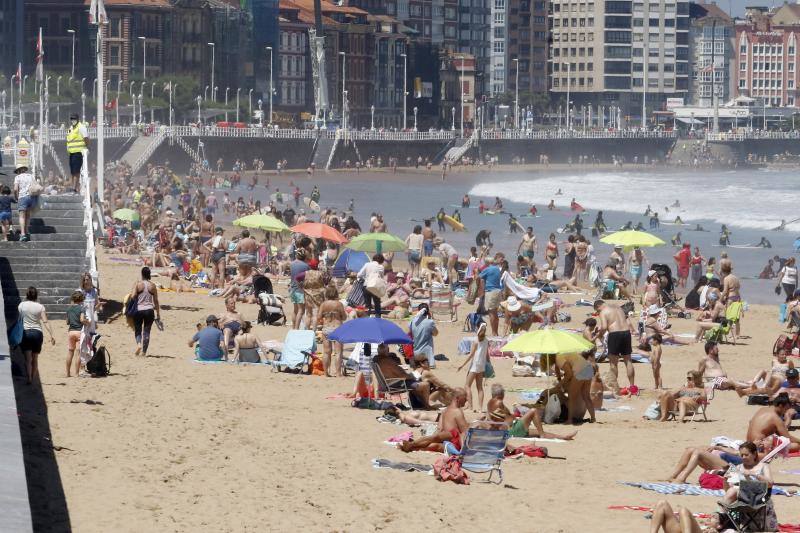 Asturianos y visitantes despiden junio con unas elevadas temperaturas que les ha llevado hasta playas y zonas de paseo con sombra.