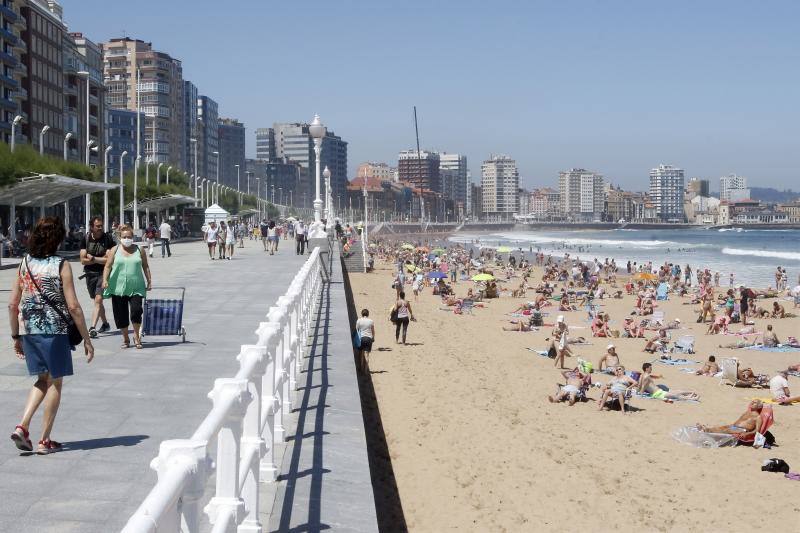 Asturianos y visitantes despiden junio con unas elevadas temperaturas que les ha llevado hasta playas y zonas de paseo con sombra.