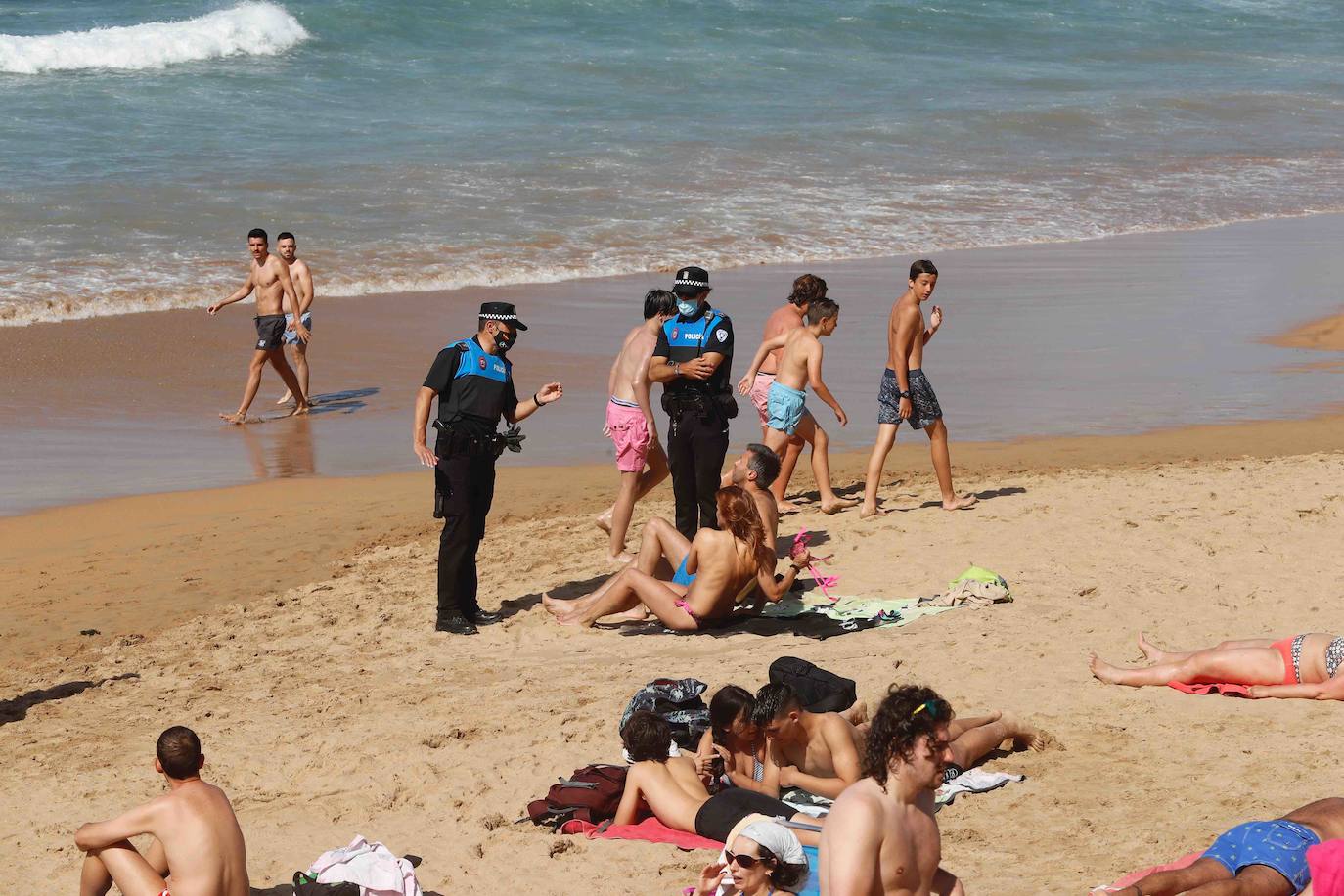 Gijoneses y visitantes han disfrutado del sol y del buen tiempo este martes en las playas. San Lorenzo se ha llenado de bañistas y la Policía Local de Gijón ha intervenido para garantizar el cumplimiento de las medidas de seguridad. 