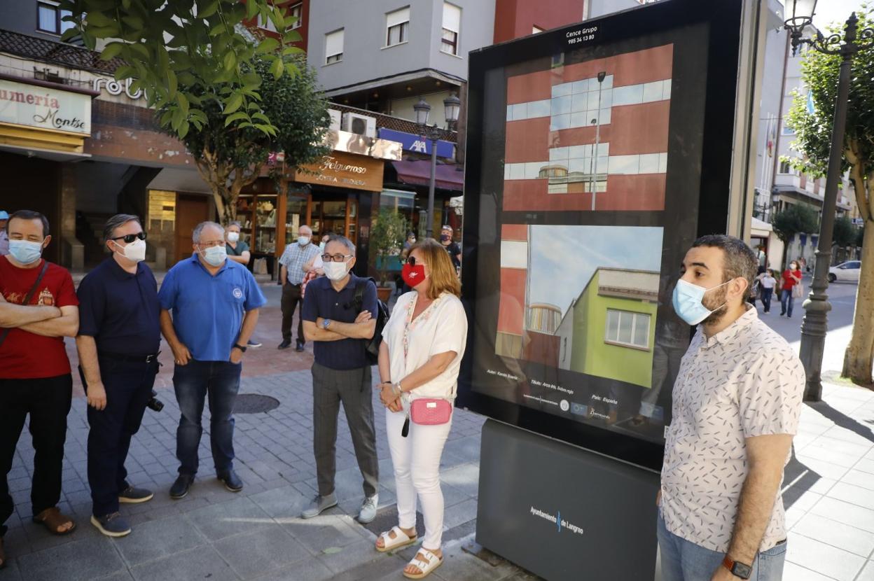 Las autoridades langreanas, junto a una de las fotografías. 