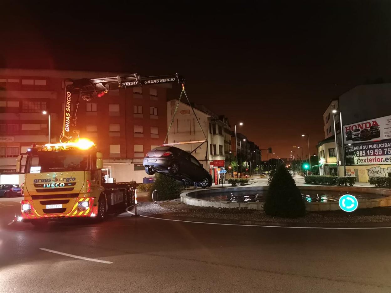 La grúa saca el coche de la fuente de Lugones. 