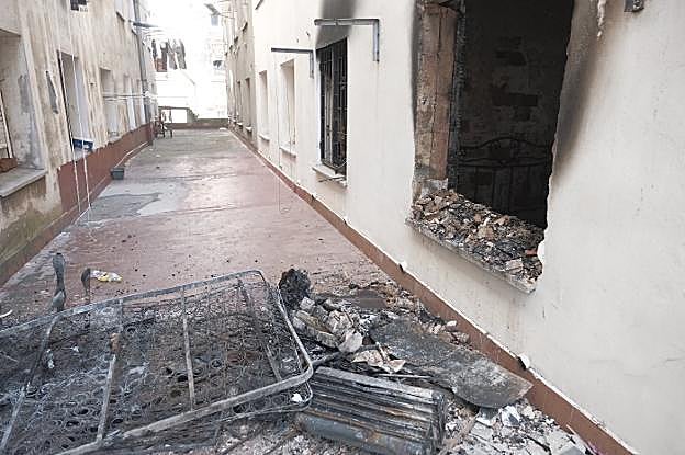El bloque acabó con paredes y suelo ennegrecidos. La habitación quedó inhabilitada tras el fuego. La Policía Local y los Bomberos sacaron al patio piezas calcinadas del interior. 