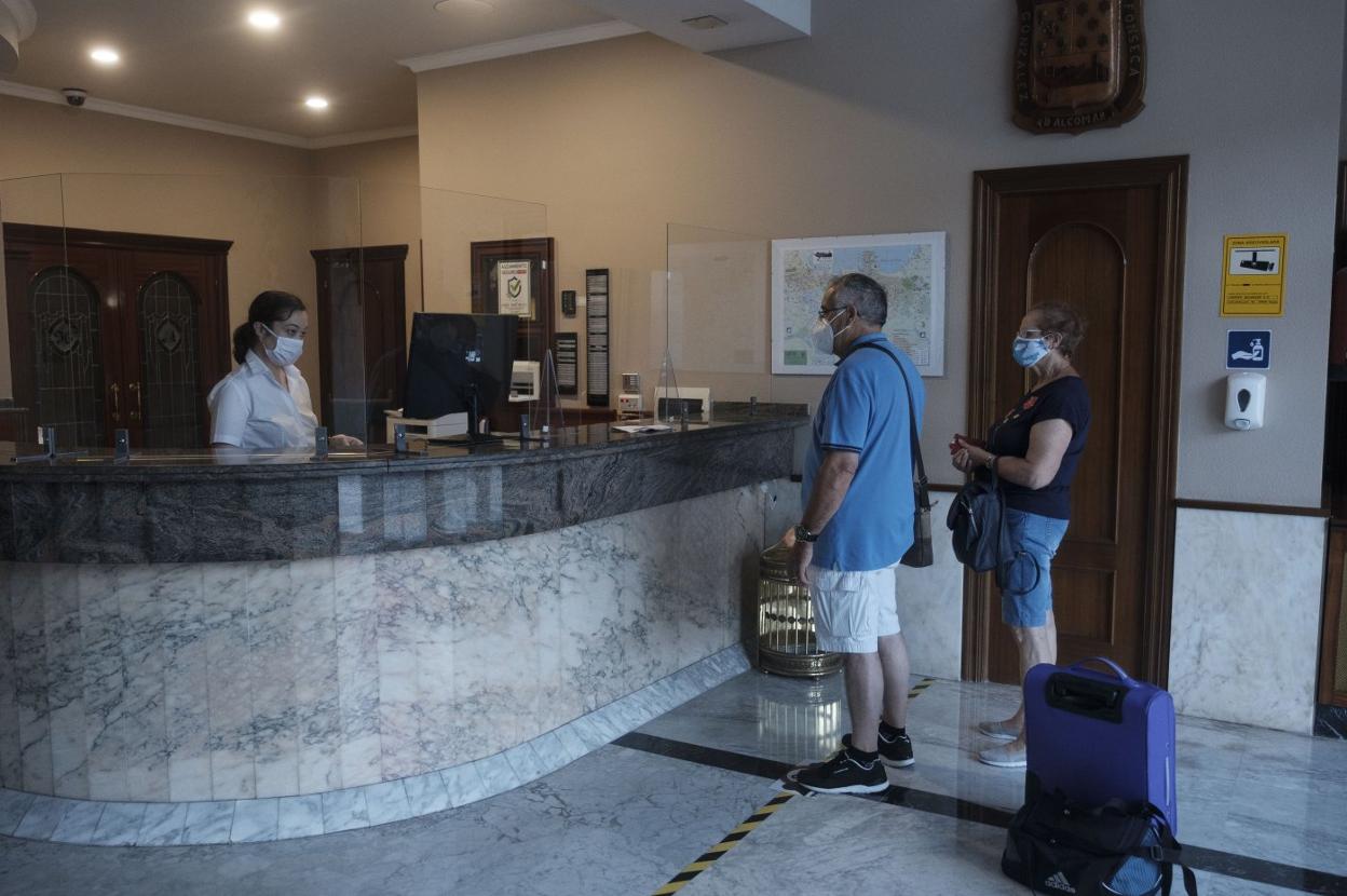 Dos turistas, con su equipaje, en un hotel de Gijón. 