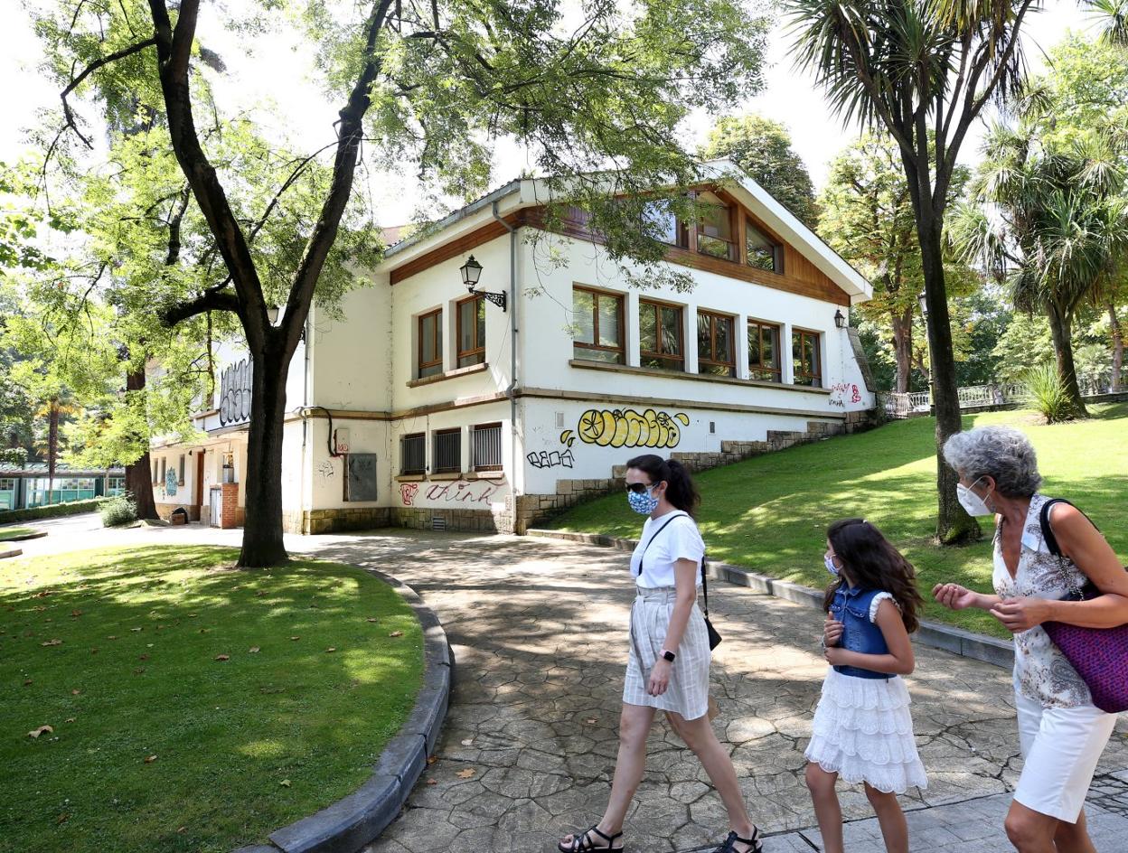 Tres mujeres pasean junto a la biblioteca de La Granja, que tiene numerosos grafitis. 