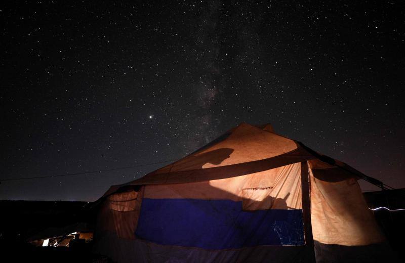 Parece que el mundo se detiene al observar el cielo estrellado de Idlib (Siria). Sin embargo, basta con bajar un poco la mirada para darse cuenta de la realidad: edificios destruidos por una guerra que comenzó hace más de nueve años y que parece no tener fin, un campamento para sirios desplazados, un parque de atracciones abandonado y combatientes a lo largo de la primera línea con las fuerzas gubernamentales. Así son las noches en la provincia de Idlib, controlada por los rebeldes sirios. 