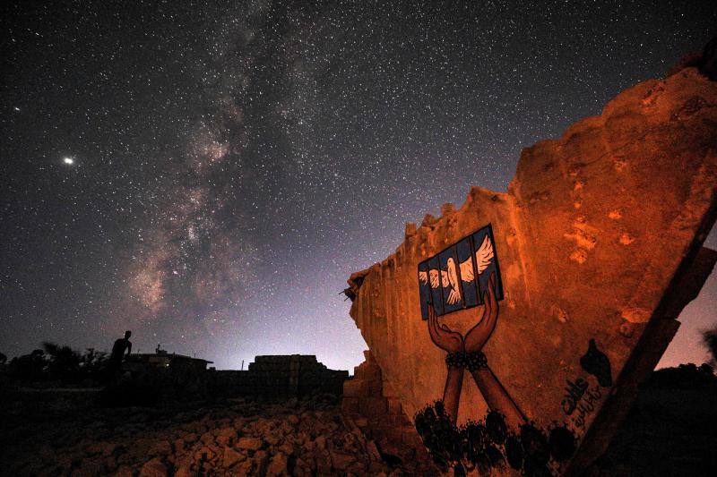 Parece que el mundo se detiene al observar el cielo estrellado de Idlib (Siria). Sin embargo, basta con bajar un poco la mirada para darse cuenta de la realidad: edificios destruidos por una guerra que comenzó hace más de nueve años y que parece no tener fin, un campamento para sirios desplazados, un parque de atracciones abandonado y combatientes a lo largo de la primera línea con las fuerzas gubernamentales. Así son las noches en la provincia de Idlib, controlada por los rebeldes sirios. 